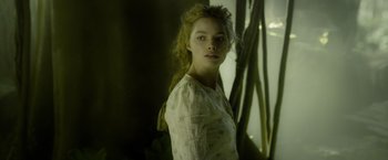 Movie still from “The Legend of Tarzan” (2016), directed by David Yates – A woman in a white shirt is posing for a picture; Medium shot, Over the shoulder angle
