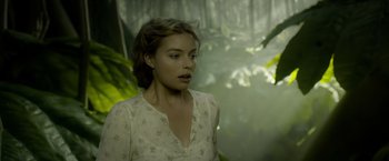 Movie still from “The Legend of Tarzan” (2016), directed by David Yates – A woman in a white shirt is standing in a forest; Close Up shot, Over the shoulder angle