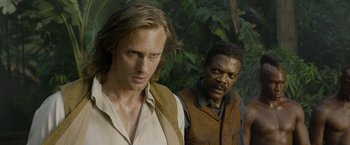 Movie still from “The Legend of Tarzan” (2016), directed by David Yates – Two men standing next to each other in front of a forest; Close Up shot, Over the shoulder angle