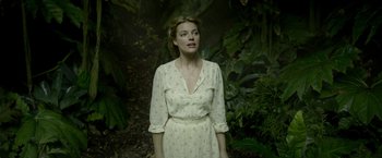 Movie still from “The Legend of Tarzan” (2016), directed by David Yates – A woman in a white dress standing in the woods; Medium shot, High angle