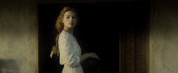 Movie still from “The Legend of Tarzan” (2016), directed by David Yates – A beautiful young lady standing in front of a wall; Close Up shot, Over the shoulder angle