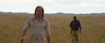 Movie still from “The Legend of Tarzan” (2016), directed by David Yates – A man and a woman walking through a field; Medium shot, Over the shoulder angle