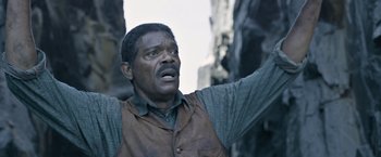 Movie still from “The Legend of Tarzan” (2016), directed by David Yates – A man in a brown vest is raising his arm; Close Up shot, High angle