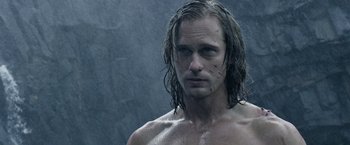Movie still from “The Legend of Tarzan” (2016), directed by David Yates – A shirtless man with wet hair in the rain; Close Up shot, Over the shoulder angle