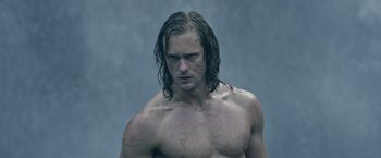 Movie still from “The Legend of Tarzan” (2016), directed by David Yates – A shirtless man with wet hair and no shirt; Medium shot, Low angle