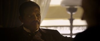 Movie still from “The Legend of Tarzan” (2016), directed by David Yates – A person wearing a suit and tie; Close Up shot, Over the shoulder angle