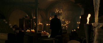 Movie still from “The Legend of Zorro” (2005), directed by Martin Campbell – A man standing in a room filled with lit candles; Wide shot, Low angle