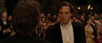 Movie still from “The Legend of Zorro” (2005), directed by Martin Campbell – A man in a tuxedo looking at another man in front of a group of onlookers; Close Up shot, Over the shoulder angle