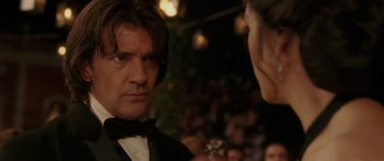 Movie still from “The Legend of Zorro” (2005), directed by Martin Campbell – A man and a woman in tuxedos at an event; Close Up shot, Over the shoulder angle