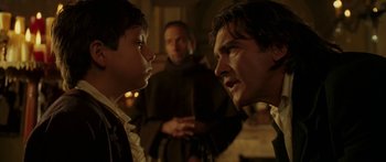 Movie still from “The Legend of Zorro” (2005), directed by Martin Campbell – A man and a boy face each other in front of a priest; Close Up shot, Over the shoulder angle