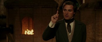 Movie still from “The Legend of Zorro” (2005), directed by Martin Campbell – A man wearing a suit and tie pointing to the sky; Close Up shot, Over the shoulder angle