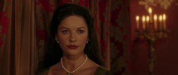 Movie still from “The Legend of Zorro” (2005), directed by Martin Campbell – A woman wearing a pearl necklace and a green dress; Close Up shot, Over the shoulder angle