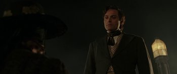 Movie still from “The Legend of Zorro” (2005), directed by Martin Campbell – A man wearing a suit and tie standing in front of a dog; Close Up shot, Over the shoulder angle