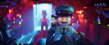Movie still from “The Lego Batman Movie” (2017), directed by Chris McKay – A lego figure is sitting in front of a blurry background; Close Up shot, Over the shoulder angle