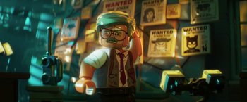 Movie still from “The Lego Batman Movie” (2017), directed by Chris McKay – A lego character is standing in front of a bunch of wanted posters; Close Up shot, Over the shoulder angle