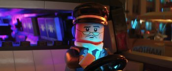 Movie still from “The Lego Batman Movie” (2017), directed by Chris McKay – A lego figure is sitting in the drivers seat of a car; Close Up shot, Over the shoulder angle