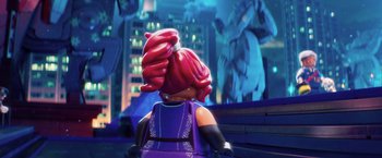 Movie still from “The Lego Batman Movie” (2017), directed by Chris McKay – A lego figure with red hair sitting in a room; Extreme Wide shot, Over the shoulder angle