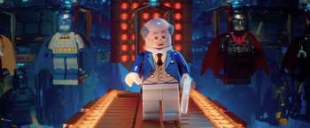 Movie still from “The Lego Batman Movie” (2017), directed by Chris McKay – A lego figure is standing on a platform; Close Up shot, Over the shoulder angle