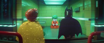 Movie still from “The Lego Batman Movie” (2017), directed by Chris McKay – A lego joker sitting in a chair in front of two other legos; Wide shot, Over the shoulder angle