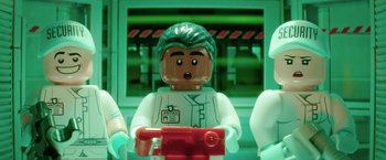 Movie still from “The Lego Batman Movie” (2017), directed by Chris McKay – A lego figure of a doctor holding a red camera; Extreme Close Up shot, Overhead angle