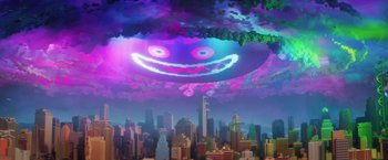 Movie still from “The Lego Batman Movie” (2017), directed by Chris McKay – An image of an image of a smiling face in the sky above a city; Extreme Wide shot, Low angle