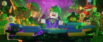 Movie still from “The Lego Batman Movie” (2017), directed by Chris McKay – A lego joker is sitting in front of a bunch of dinosaurs; Medium shot, Over the shoulder angle
