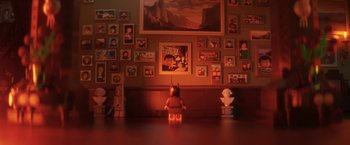 Movie still from “The Lego Batman Movie” (2017), directed by Chris McKay – A lego figure sitting in front of a wall of movie posters; Wide shot, High angle
