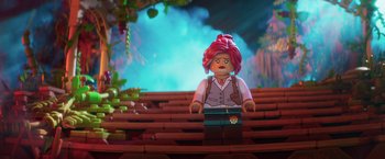 Movie still from “The Lego Batman Movie” (2017), directed by Chris McKay – A lego character sitting on some steps in a forest; Close Up shot, Over the shoulder angle