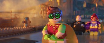 Movie still from “The Lego Batman Movie” (2017), directed by Chris McKay – A lego robin sitting in front of a city; Close Up shot, Over the shoulder angle