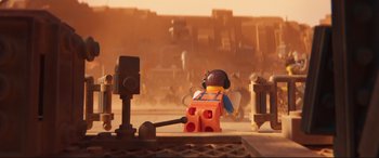 Movie still from “The Lego Movie 2: The Second Part” (2019), directed by Mike Mitchell – A lego figure sitting on top of an orange object; Extreme Wide shot, High angle