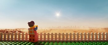 Movie still from “The Lego Movie 2: The Second Part” (2019), directed by Mike Mitchell – A lego figure sitting in front of a white picket fence; Extreme Wide shot, Over the shoulder angle