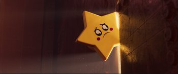 Movie still from “The Lego Movie 2: The Second Part” (2019), directed by Mike Mitchell – A yellow star with a sad face on it's side; Close Up shot, Overhead angle