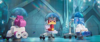 Movie still from “The Lego Movie 2: The Second Part” (2019), directed by Mike Mitchell – A toy cat sitting under an umbrella on a table; Wide shot, Over the shoulder angle