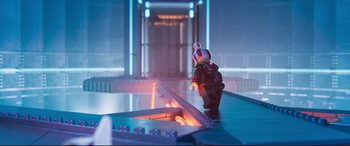 Movie still from “The Lego Movie 2: The Second Part” (2019), directed by Mike Mitchell – A lego figure walking along a ramp in a building; Extreme Wide shot, Over the shoulder angle