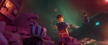 Movie still from “The Lego Movie 2: The Second Part” (2019), directed by Mike Mitchell – A lego figure is standing on a pile of legos; Medium shot, Over the shoulder angle