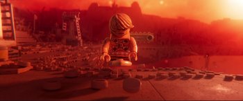 Movie still from “The Lego Movie 2: The Second Part” (2019), directed by Mike Mitchell – A lego figure is sitting on top of a pile of coins; Wide shot, High angle