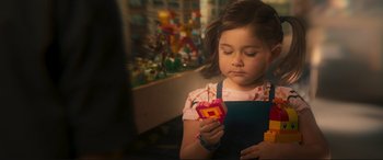 Movie still from “The Lego Movie 2: The Second Part” (2019), directed by Mike Mitchell – A little girl is holding a toy in her hands; Close Up shot, Over the shoulder angle