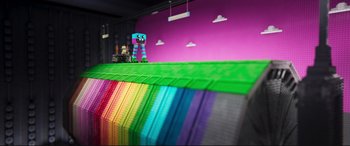 Movie still from “The Lego Movie 2: The Second Part” (2019), directed by Mike Mitchell – A toy is sitting on top of a table near a wall; Extreme Wide shot, Overhead angle