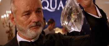 Movie still from “The Life Aquatic with Steve Zissou” (2004), directed by Wes Anderson – An older man holding a plastic bag in front of him; Close Up shot, Over the shoulder angle