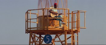 Movie still from “The Life Aquatic with Steve Zissou” (2004), directed by Wes Anderson – A man sitting on top of a wooden platform; Extreme Wide shot, Low angle