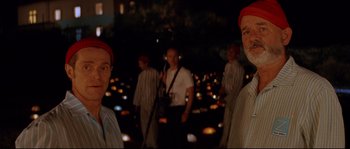 Movie still from “The Life Aquatic with Steve Zissou” (2004), directed by Wes Anderson – A group of men standing in the middle of a field; Close Up shot, Over the shoulder angle
