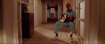 Movie still from “The Life Aquatic with Steve Zissou” (2004), directed by Wes Anderson – A man sitting on a chair playing a guitar; Wide shot, High angle