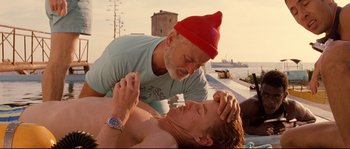 Movie still from “The Life Aquatic with Steve Zissou” (2004), directed by Wes Anderson – An older man and a younger man laying on the ground; Medium shot, Low angle