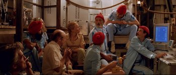 Movie still from “The Life Aquatic with Steve Zissou” (2004), directed by Wes Anderson – A group of people sitting around a room; Wide shot, Low angle
