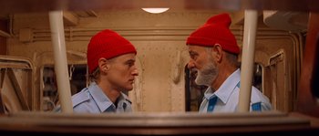 Movie still from “The Life Aquatic with Steve Zissou” (2004), directed by Wes Anderson – A man wearing a red hat looking at himself in the mirror; Close Up shot, Low angle