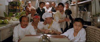 Movie still from “The Life Aquatic with Steve Zissou” (2004), directed by Wes Anderson – A group of people in a room with a chef; Medium shot, High angle