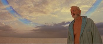 Movie still from “The Life Aquatic with Steve Zissou” (2004), directed by Wes Anderson – A man standing in front of a body of water; Medium shot, Low angle