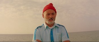 Movie still from “The Life Aquatic with Steve Zissou” (2004), directed by Wes Anderson – An older man wearing a red hat and a blue shirt; Close Up shot, Low angle