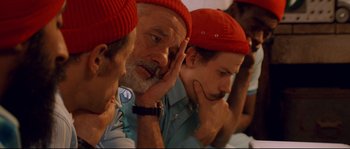 Movie still from “The Life Aquatic with Steve Zissou” (2004), directed by Wes Anderson – A group of people wearing red hats and looking at each other; Close Up shot, Low angle
