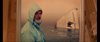 Movie still from “The Life Aquatic with Steve Zissou” (2004), directed by Wes Anderson – A man standing in front of a boat in the water; Medium shot, Low angle